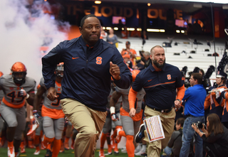 Dino Babers (left) and Sean Edinger (right) run out of the tunnel before Syracuse faces No. 17 Virginia Tech. 