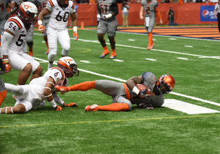 A Syracuse player is tackled near the line of scrimmage by Virginia Tech safety Mook Reynolds