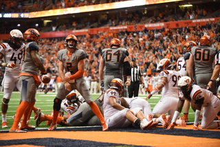 Dungey celebrates the touchdown as VT players pick themselves off the pile. He's been running a lot despite Babers' declaration that the coach had to strip Dungey down and make him more of a passer. 