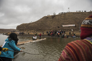 Police wait on top of Turtle Island on Thanksgiving Day as water protectors travel across first with canoes and then with their rudimentary bridge.